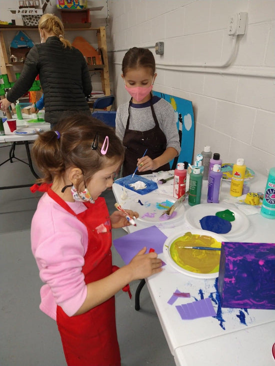 two girls working together on a craft project