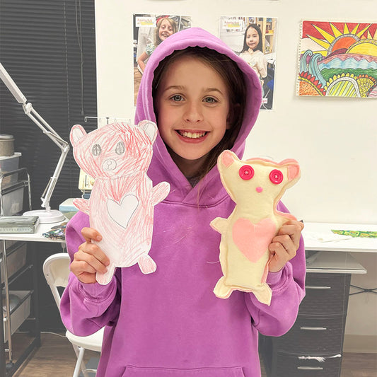 Student showing her design drawing and finished sewing project in a kids Design and Sewing class in Schaumburg