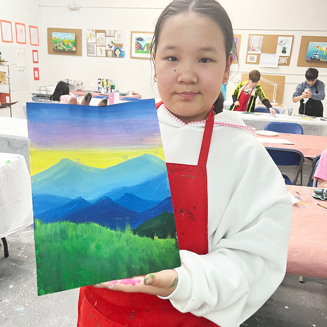 Student proudly holding her landscape painting created in our kids Painting & Drawing class in Schaumburg.