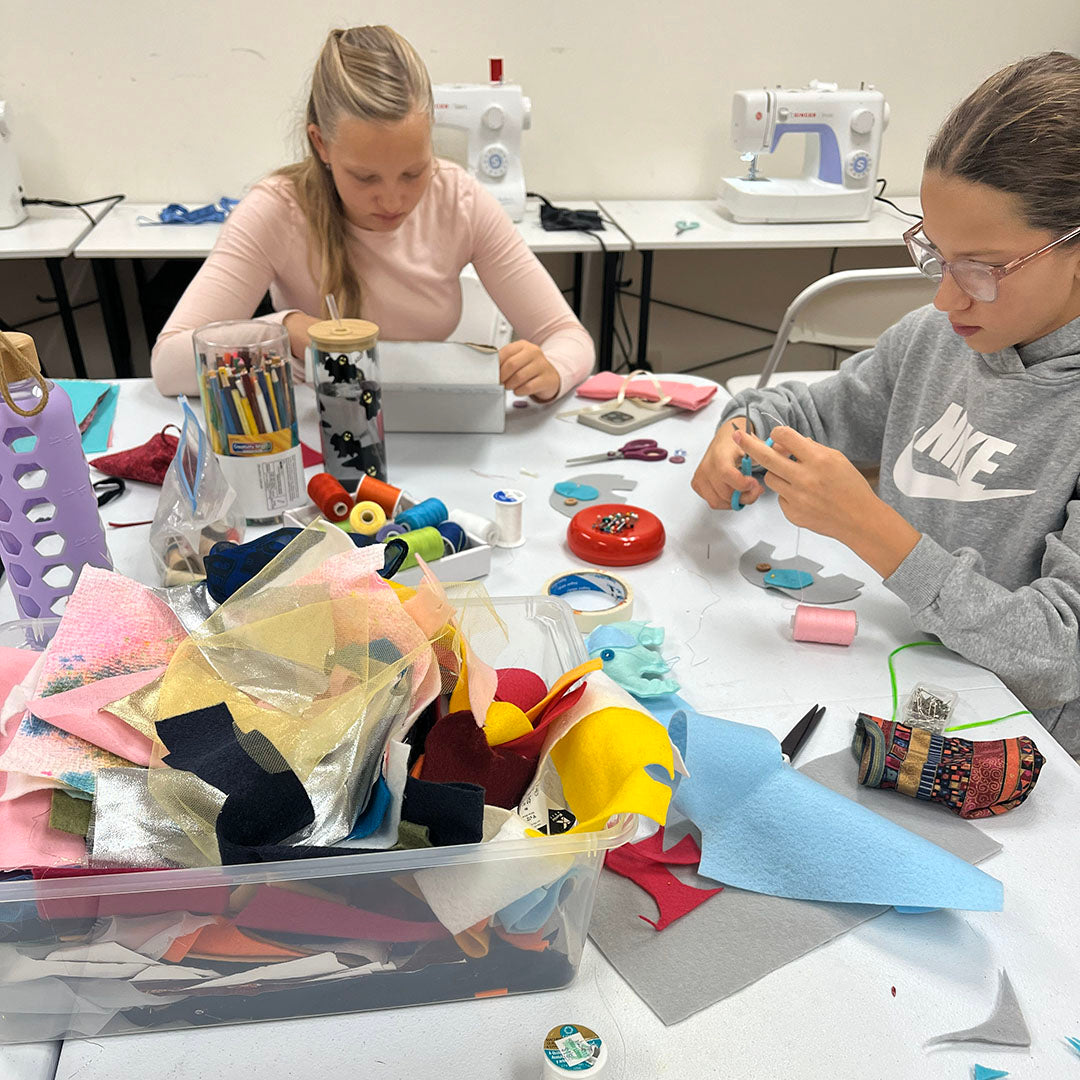 Young artists focused on a hands-on creative process inside an art atelier.